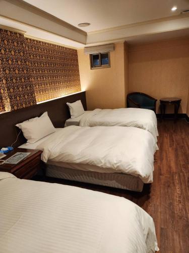 a room with two beds in a hotel room at 爵起商務飯店 in Taoyuan