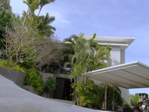 a building with palm trees in front of it at Phuket 4-Bedrooms Seaview 884m2 Private XL Luxury Infinity Pool Villa in Ban Pa Khlok