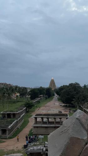 a view of a road with a pyramid in the background at Mahesh Guest House in Hampi