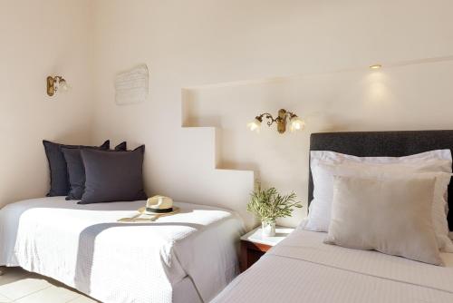 two beds sitting next to each other in a bedroom at Aneroussa Beach Hotel in Batsi