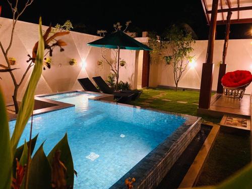 a large swimming pool in a backyard at night at Moonrise villa in Tangalle