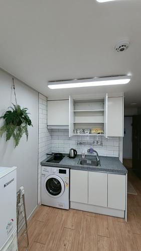 a kitchen with a stove and a washing machine at Incheon Intl Airport ANN Guest House in Incheon