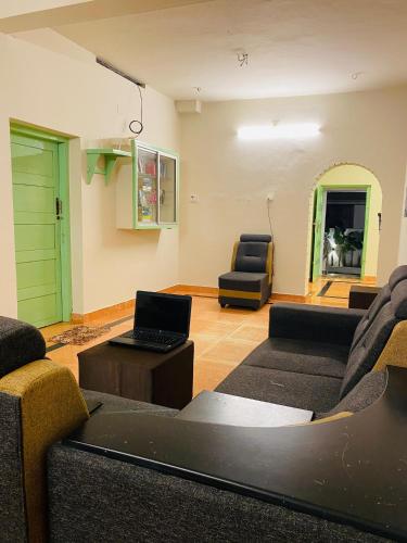 a living room with a couch and a laptop on a table at VILLA CALATHEA Varkala in Varkala