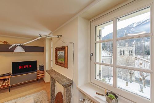 a living room with a large window and a tv at "Vue Du Clocher" - Etroubles Boutique Apartment in Etroubles