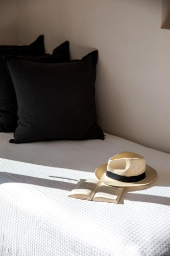 a hat sitting on top of a bed at Aneroussa Beach Hotel in Batsi