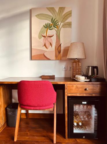 a desk with a red chair next to a fireplace at Plawa Laguna Bali in Canggu