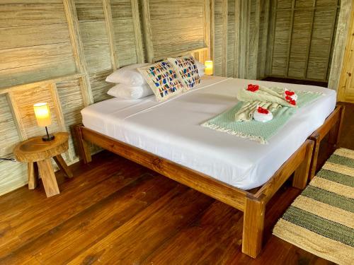 a bed in a room with two lamps and a table at Bird Island Bungalows in Bocas del Toro