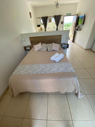 a bedroom with a large bed with two towels on it at AROMA DEL POTRERO PISCINA CLIMATIZADA CUBIERTA disponible desde Septiembre in Potrero de los Funes