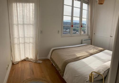a white bedroom with a bed and two windows at Golf & Rempart in Angoulême