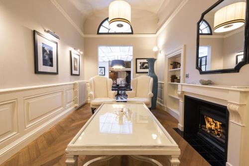 a living room with a fireplace and a table at Rinascimento Privato by MMega in Florence