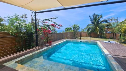 a swimming pool in a backyard with an umbrella at Moorea - Villa Pool & Chill in Maharepa