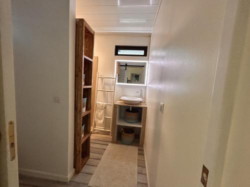 a hallway with a bathroom with a sink and a mirror at Moorea - Villa Pool & Chill in Maharepa