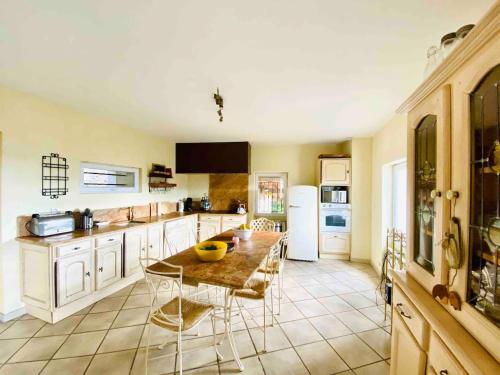 une cuisine avec une table, des chaises et un réfrigérateur dans l'établissement Mas de Campelle, au Vigan