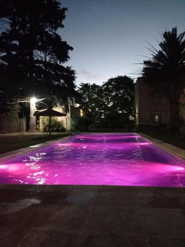 an empty driveway with pink lights on it at night at Las Moras Multiespacio in Cucha Cucha