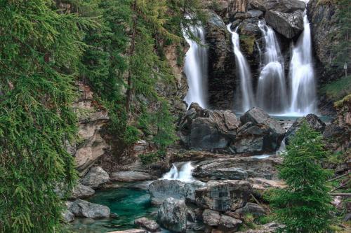 una cascada en las montañas con agua verde en Maison du Château Sarre, en Aosta