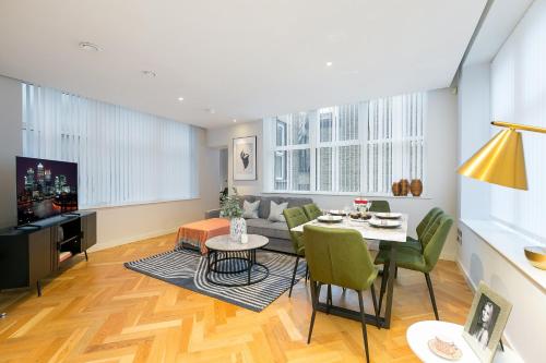a living room with a table and green chairs at Urban Chic - Camden in London