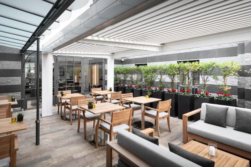 a restaurant with tables and couches and flowers at LHP Hotel River & SPA in Florence