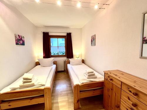 zwei Einzelbetten in einem Zimmer mit Fenster in der Unterkunft Appartementhaus Königstraße Ferienwohnung Linderhof in Füssen