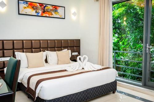 a bedroom with a bed and a window at Viveka Hotel Colombo in Colombo