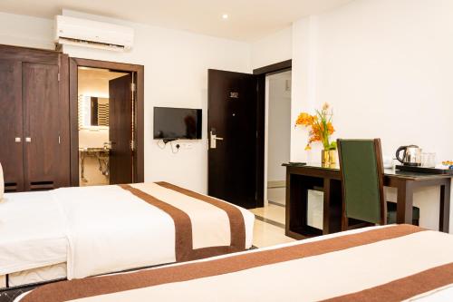 a bedroom with a bed and a desk with a computer at Viveka Hotel Colombo in Colombo