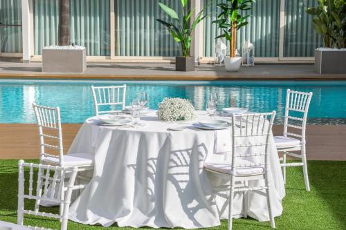 a table with white chairs and a white table cloth at Hotel I Gigli in Nola