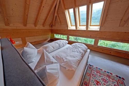 a room with two beds in a room with windows at Haldenhof, Design Retreat im Schwarzwald by living TIMELESS in Simonswald