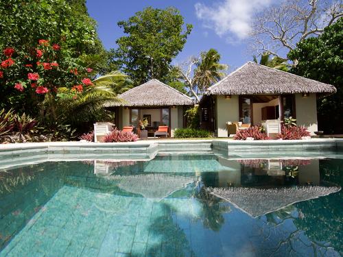 a villa with a swimming pool and a house at Eratap Beach Resort in Port Vila