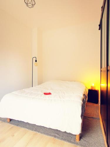 une chambre avec un lit blanc et une lampe dans l'établissement Studio bas Sablon - 50m plage, à Saint-Malo