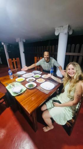 a man and a woman sitting at a table at Bliss Inn in Udawalawe