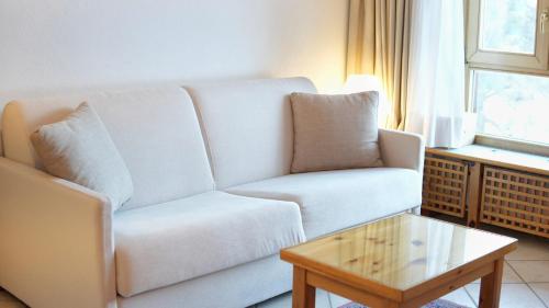 a living room with a white couch and a coffee table at Residenza Del Sole in Gressoney-Saint-Jean