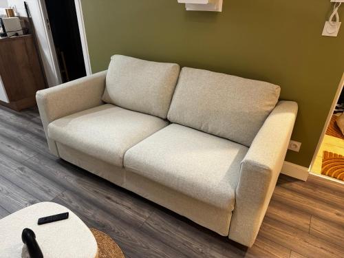 a couch in a living room with a table at Pause Nature Savane in Ennevelin