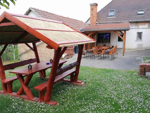 a picnic table and benches in a yard at Kettős Csárda Szálláshely Bocfölde in Bocfölde