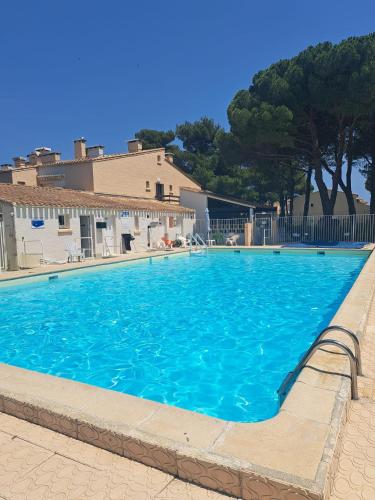 une grande piscine bleue devant un immeuble dans l'établissement cap ou pas cap, au Cap d'Agde
