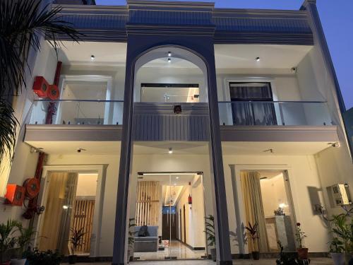 a large white house with a large mirror in front of it at Hotel Taj Way by Jyoti Villa in Agra