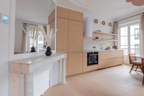 une cuisine avec des placards en bois et une cheminée dans l'établissement Amazing flat - center of paris, à Paris