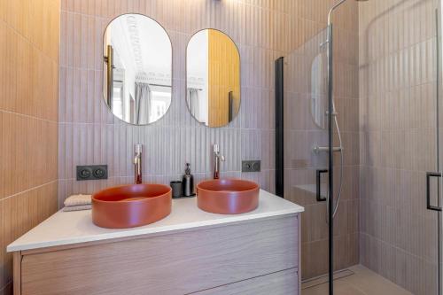 deux lavabos dans une salle de bain avec deux miroirs dans l'établissement Amazing flat - center of paris, à Paris