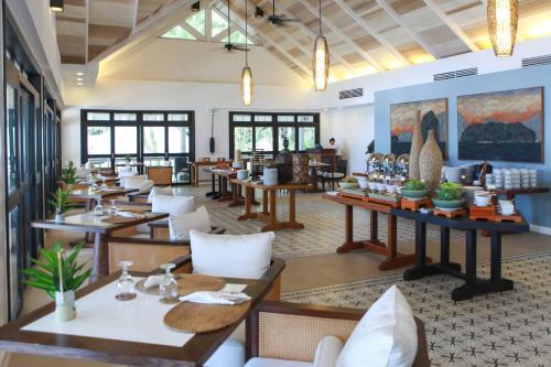 a restaurant with tables and chairs in a room at El Nido Resorts Lagen Island in El Nido