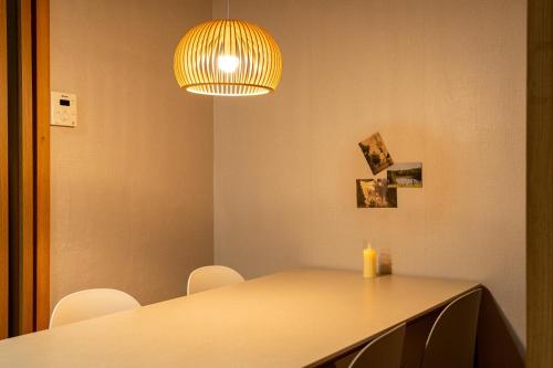a dining table with chairs and a light fixture at Dal Stay in Seoul