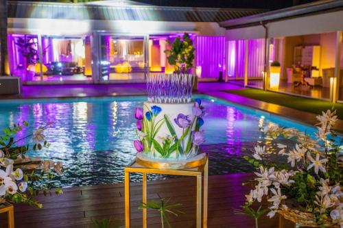a wedding cake on a table in front of a pool at Hotel I Gigli in Nola