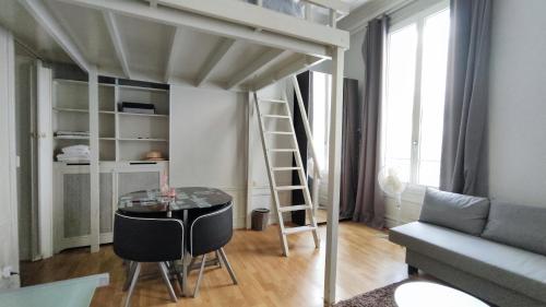 Cette chambre comprend une mezzanine avec une table et des chaises. dans l'établissement Rue Paul Valery - Paris 16 - 1160, à Paris