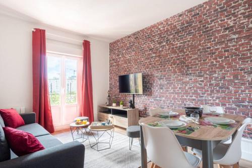 - un salon avec un mur en briques et une table dans l'établissement Bella Vita - Quartier rénové, au Havre