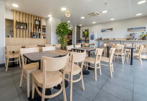 a dining room with tables and chairs in a restaurant at B&B HOTEL Royan La Palmyre in Vaux-sur-Mer