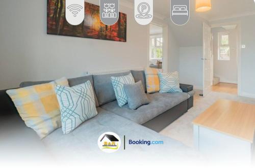 a living room with a gray couch with colorful pillows at 3 Bed Detached House By B and R Serviced Accommodation Amesbury With Free Parking & Garden in Amesbury