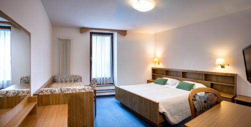 a hotel room with a bed and a table at Hotel Al Polo in Ziano di Fiemme