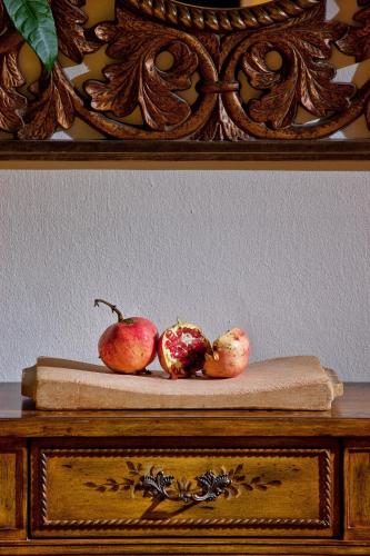 two pomegranates sitting on top of a wooden table at Mrs Chryssana Beach Hotel in Kolymvari