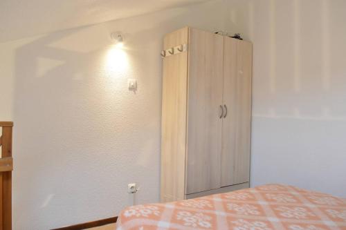 - une chambre avec une armoire en bois à côté d'un lit dans l'établissement SP310-093 Maison studio cabine mezzanine SAINT PIERRE LA MER, à Saint Pierre La Mer