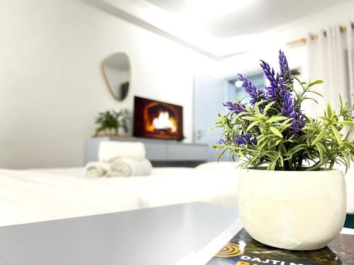 a white vase with purple flowers on a table at Tirana Square Hotel in Tirana