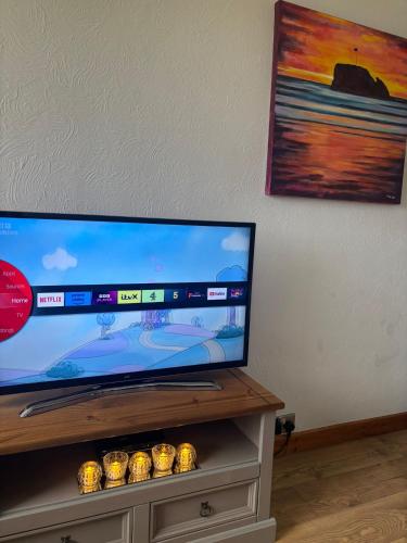 a flat screen tv sitting on top of a table at Dunes View - Atlantic Bay in Perranporth