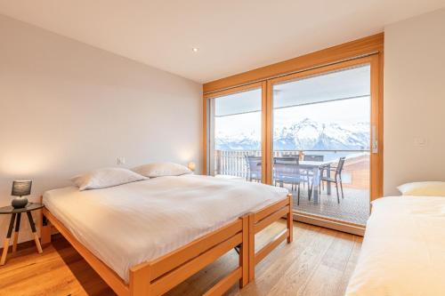 a bedroom with a bed and a large window at Ski Heaven SH 003 - LUXE apartment 5 pers in Veysonnaz