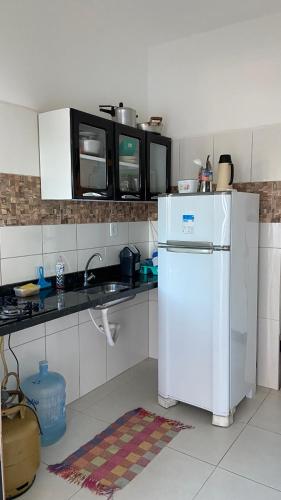 a small kitchen with a white refrigerator and cabinets at Marujo da Gávea in Prado